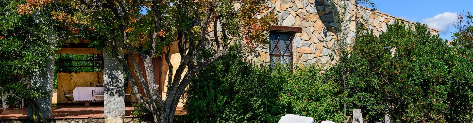 Casa Meloni 2 | Garten mit Sonnenliegen und Hauseingang zur Meloni 2 in Sant Elmo Garten mit Sonnenliegen und Hauseingang zur Meloni 2 in Sant Elmo