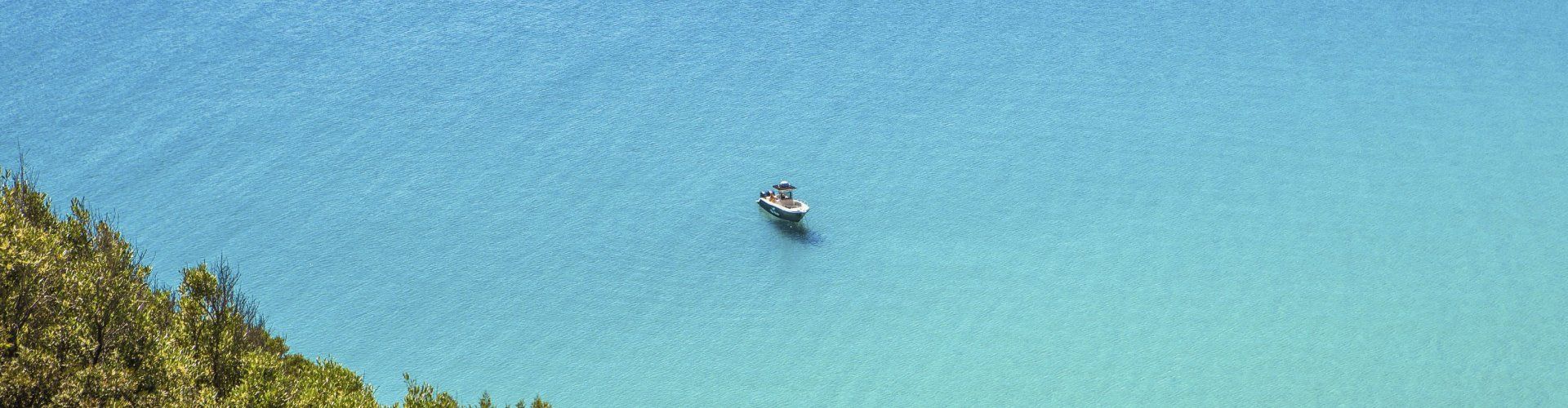 Blaues Meer mit darauf schwimmendem Motorboot, Torre delle Stelle