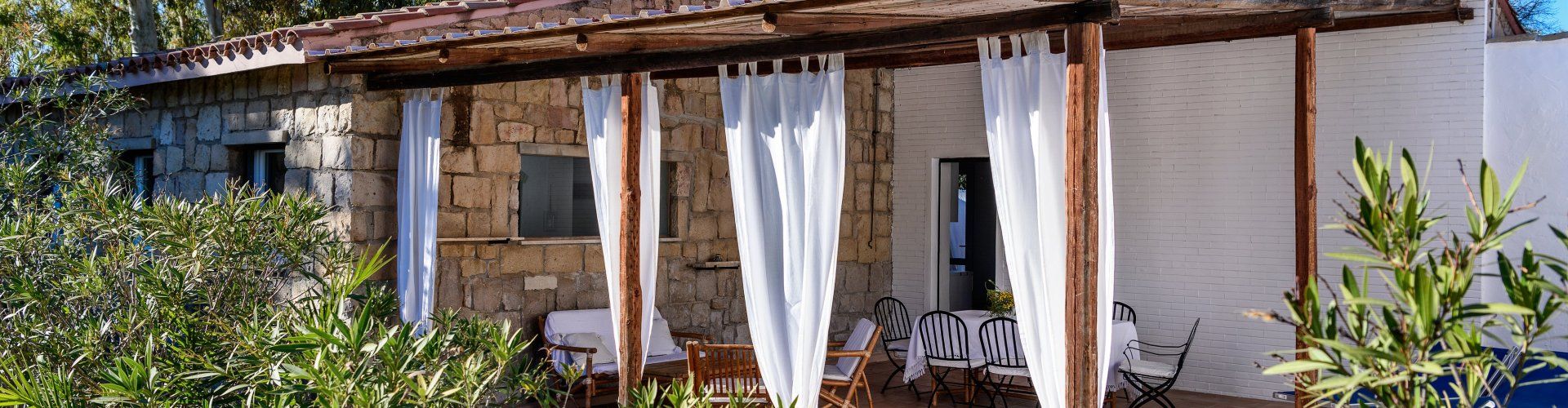 Casa Su Faru 3 | Große, überdachte, privateTerrasse mit Sofa, Esstisch und Sonnenliegen Überdachte Terrasse von Su Faru 3 Pula mit Sofa, Esstisch und Sonnenliegen