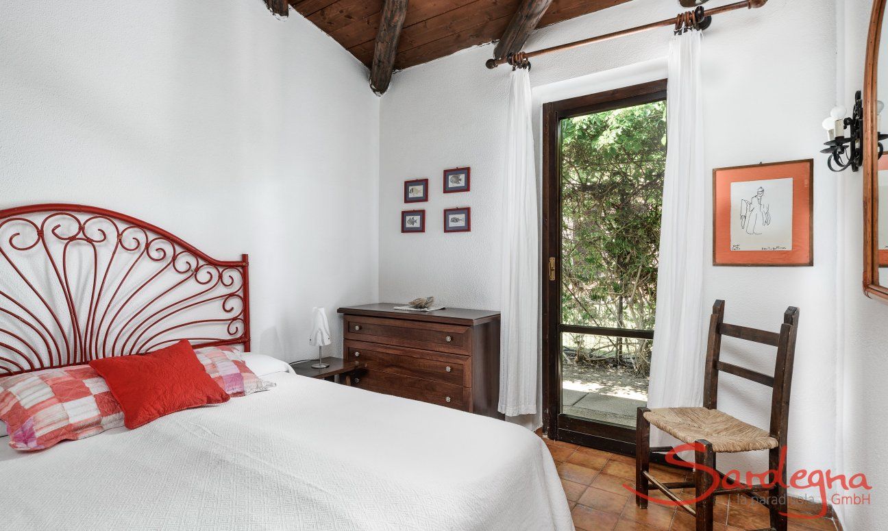Villa Romana | Schlafzimmer 1 mit Doppelbett und Tür zum Garten Villa Romana, Costa Rei, Südsardinien