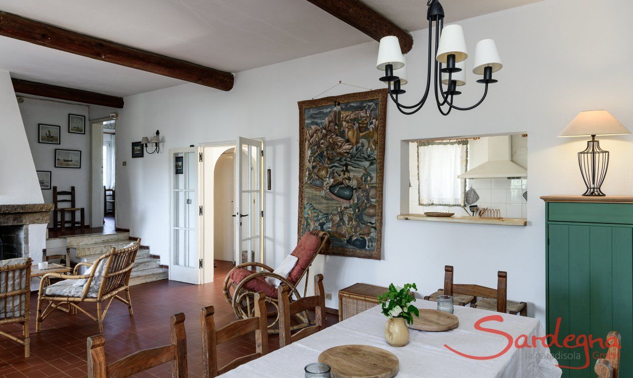Villa Bau Cannas | Wohnzimmer mit Durchreist zur Küche, Kamin und Treppenaufgang Villa Bau Cannas Torresalinas Sardinien