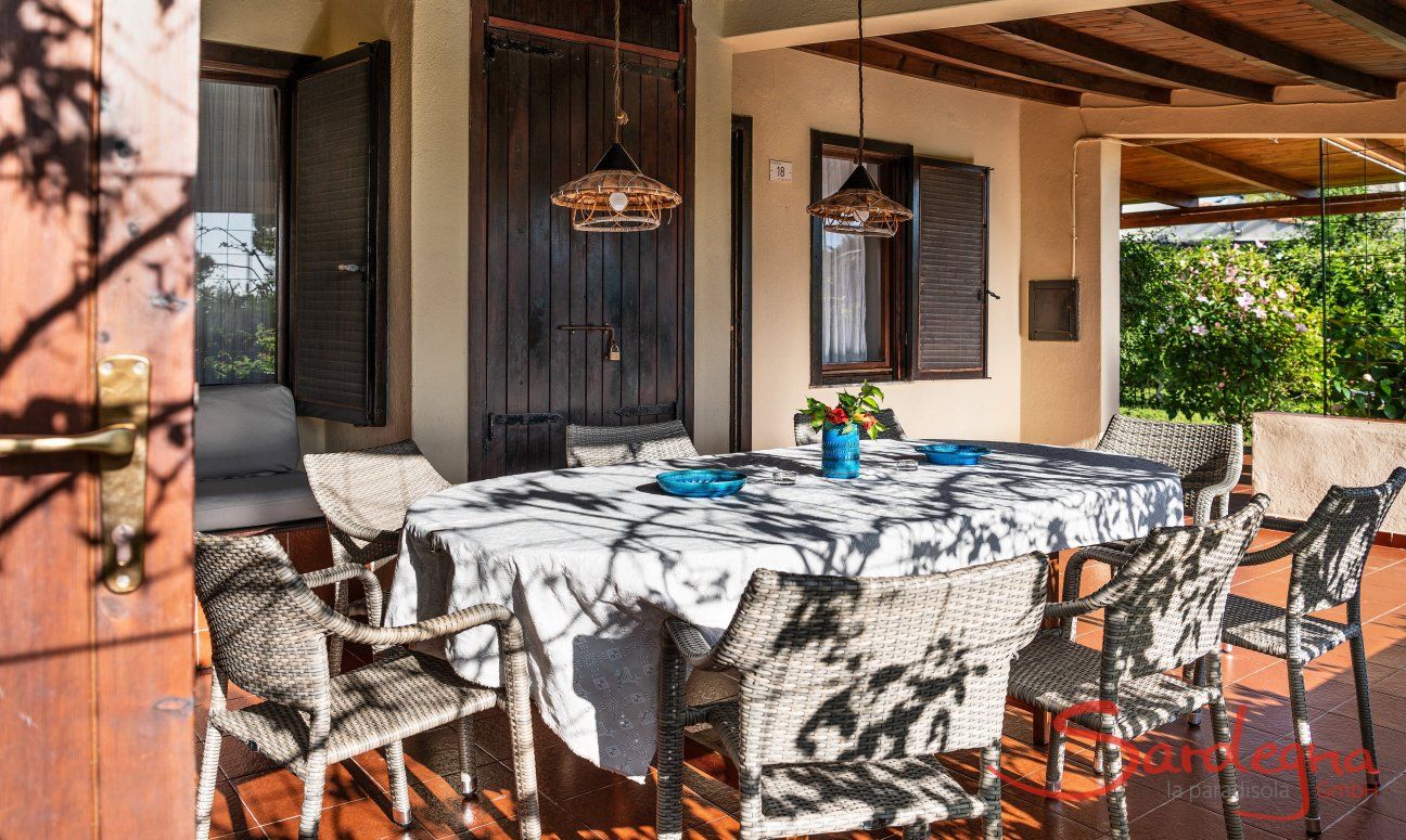 Villa Romana | Großer, ovaler Esstisch für 8 Personen auf der überdachten Terrasse Außenbereich mit Garten und Terrasse