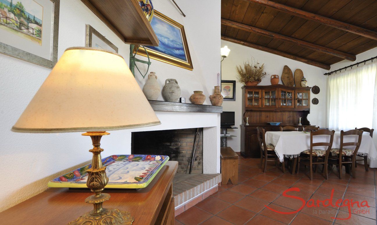 Villa Monica | Wohnzimmer mit Kamin, Sitzecke und großem Esstisch Detail