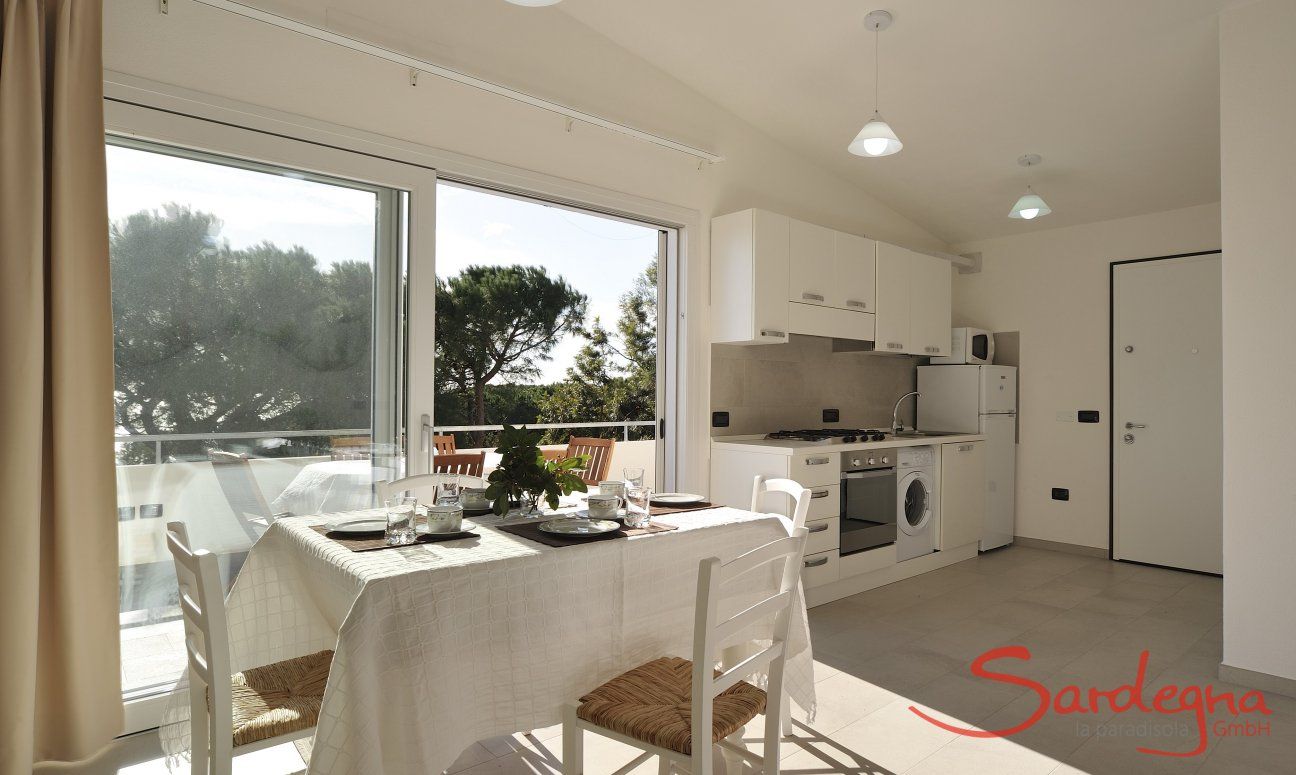 Apartment Cala Liberotto II | Essbereich mit offener Küche und Glasfront Essbereich mit offener Küche und Glasfront
