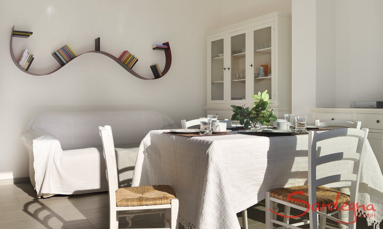 Apartment Cala Liberotto II | Esstisch und Sofa im Wohnbereich Esstisch und Sofa im Wohnbereich