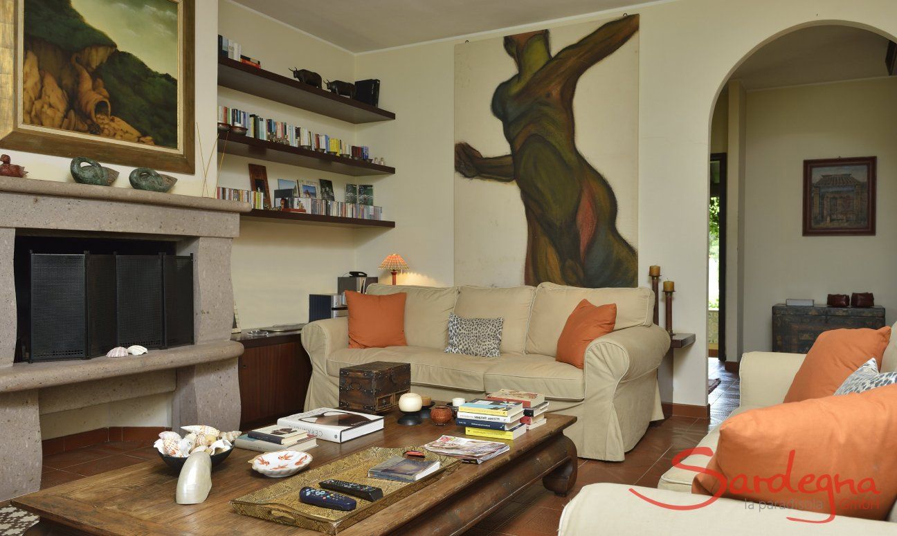 Villa Ulivi 12 | Wohnzimmer mit Stizgruppe um den Kamin und Blick in den Flur Wohnzimmer