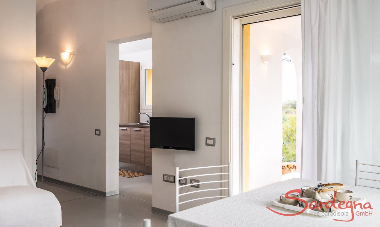 Villa Caterina | Eingangsbereich mit TV und Klimaanlage Blick zur Küche
