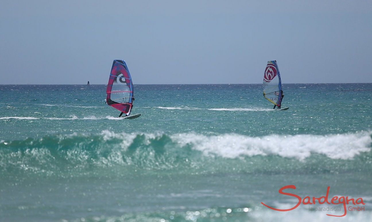 Chia | Zwei Windsurfer im glasklaren Wasser