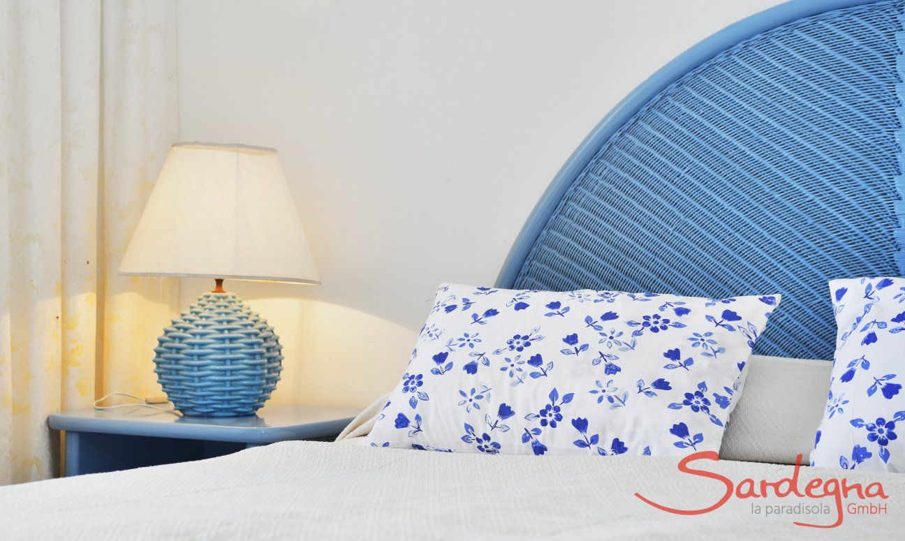 Villa Bella | Doppelbett im Schlafzimmer 1 Doppelbett mit Kopfende, Nachtisch, und Lampe in hellblau
