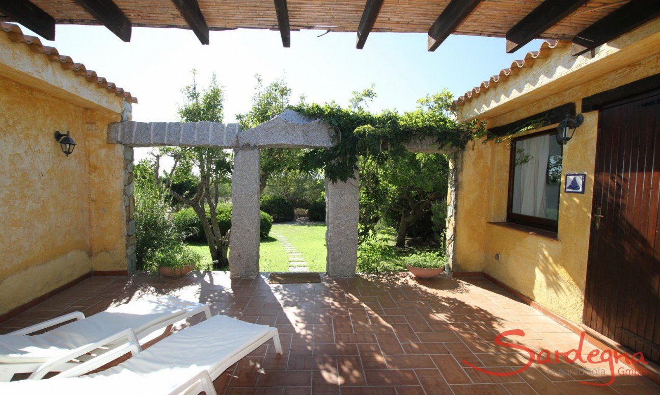 Terrasse mit Sonnenliegen und Blick auf den Garten 