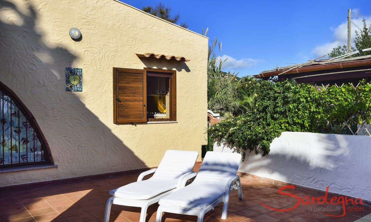 Villa Gaia | Terrasse mit Sonnenliegen und ein grosser Garten mit Tor zum Strand Terrasse mit Sonnenliegen
