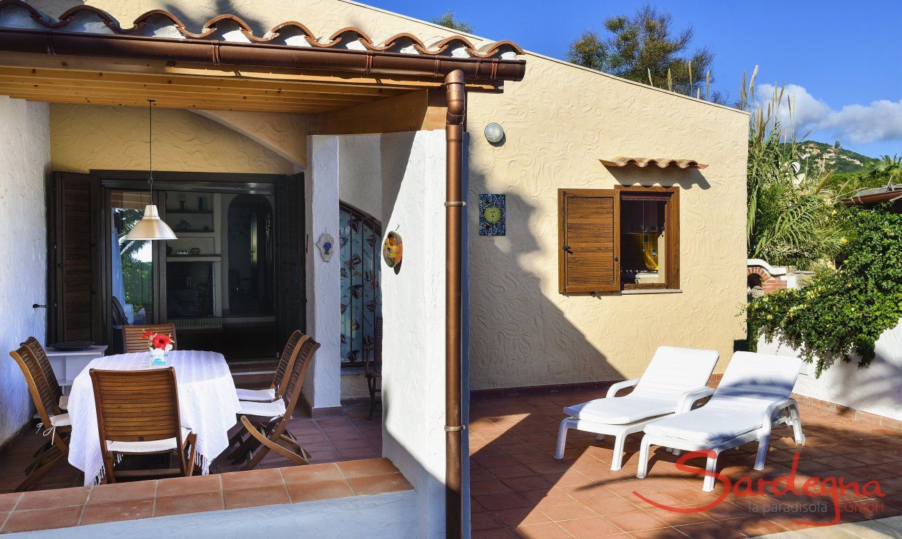 Villa Gaia | Eingang zum Haus über die teilweise überdachter Terrasse mit Esstisch und Sonnenliegen Villa Gaia
