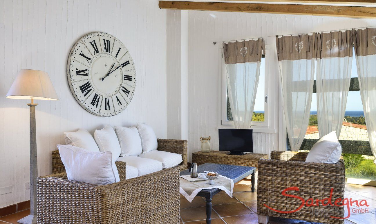 Li Conchi 9 | Moderne Sofaecke mit Meerblick zum entspannen Sofa vor großer Wanduhr und Panoramafenster Li Conchi 9, Cala Sinzias