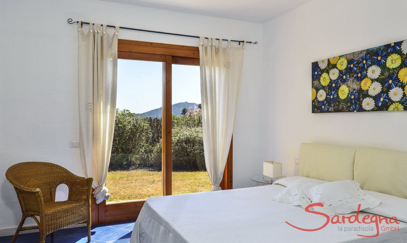 Villa Torretta Chia | Schlafzimmer 1 mit Doppelbett und Gartenzugang Schlafzimmer 1 mit Doppelbett und Gartenzugang