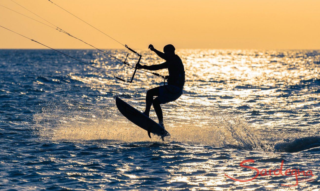 Chia | Kitesurfer in der Abendsonne Chia | Kitesurfer hebt ab vor dem gelben Himmel der Abendsonne