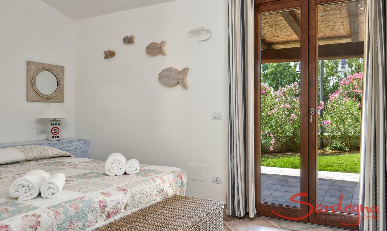 Villa Campidano 8 | Schlafzimmer 1 mit Doppelbett und Tür zum Garten Schlafzimmer und Garten