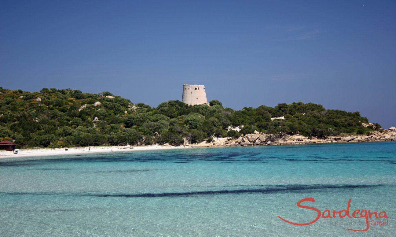 Glasklares Meer, weißer Strand und spanischer Wachtrum in der Bucht Cala Pira