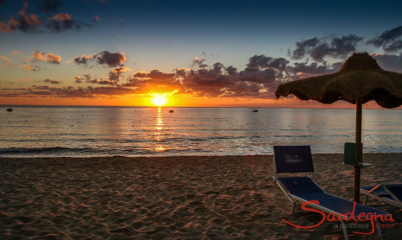Der Sonnenaufgang über dem Meer vom Strand Cala Sinzias färbt den Horizont knallorange