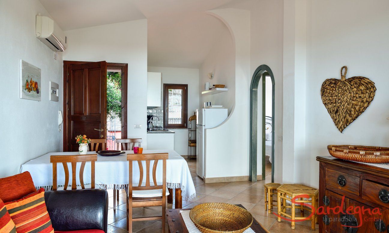 Apartment Castededdu 1 | Wohnbereich mit Sofaecke, Esstisch und Küche Wohnbereich mit Sofaecke, Esstisch und Küche