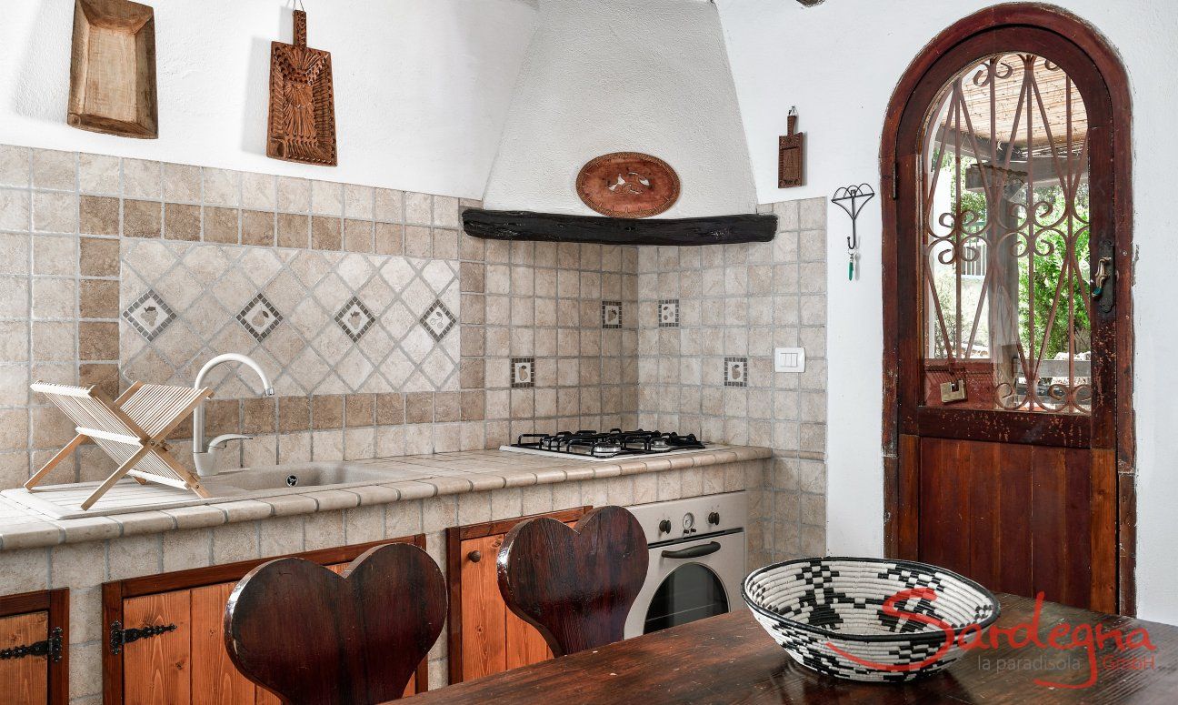Villa Liliana | Küche im Landhausstil mit Ofen und Herd und Esstisch aus Holz Küche im Landhausstil mit Ofen und Herd und Esstisch aus Holz