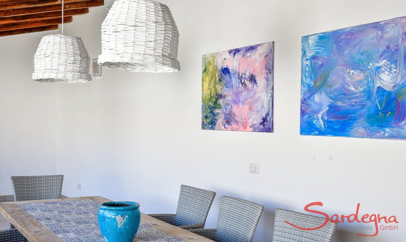 Esstisch mit eleganten Korblampen und gemalten Bildern in  Villa Campidano 20