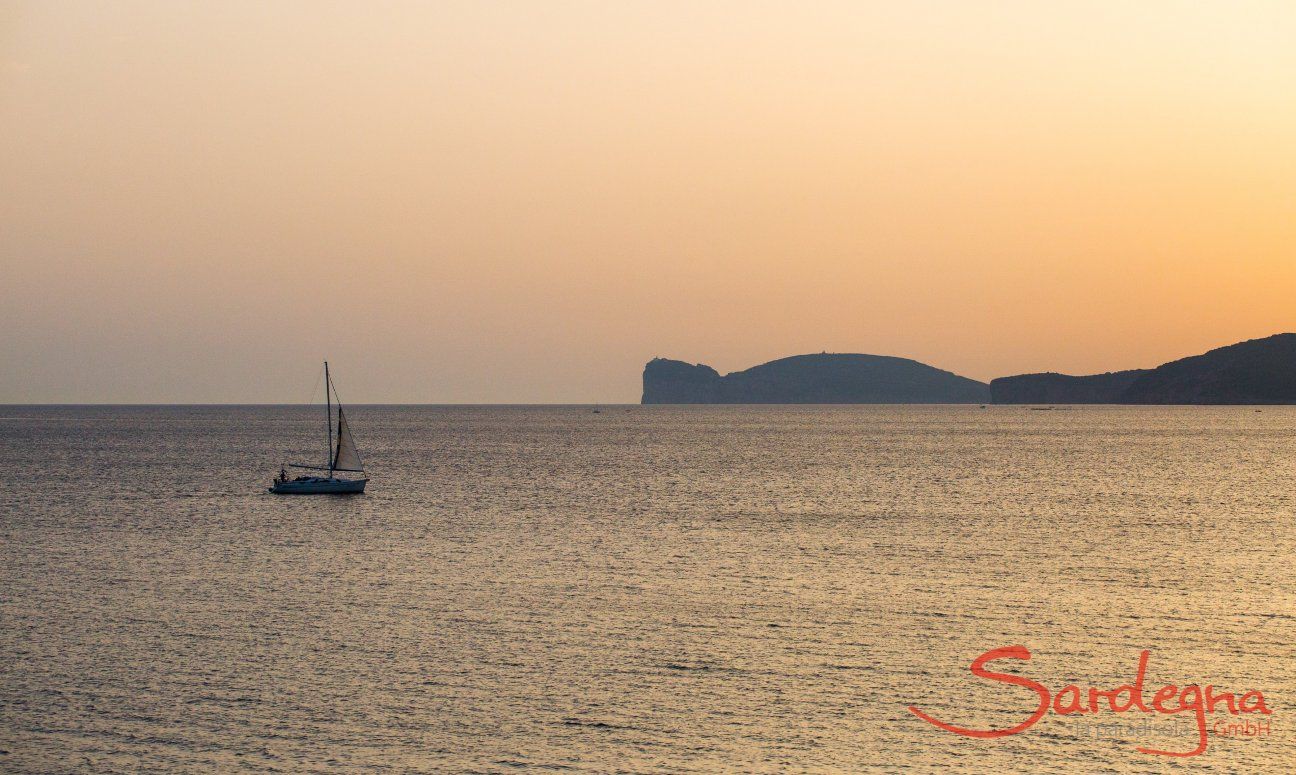 Das Meer bei Alghero beim Sonnenuntergang mit einem Segelboot und der Silhouette vom Capo Caccia