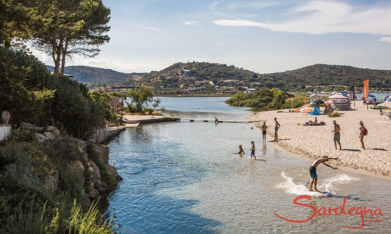 Kinder spielen im seichten Wasser der Lagune von Porto Taverna