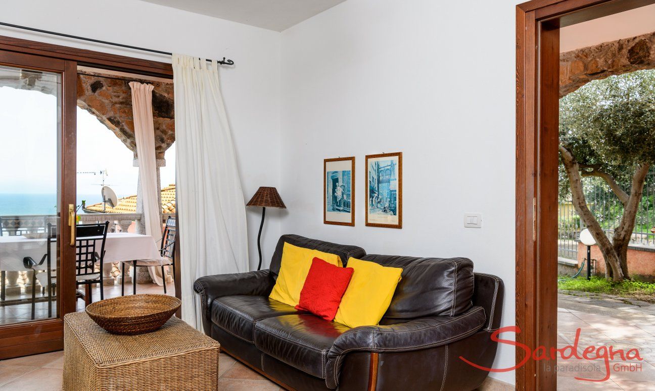 Apartment Castededdu 2 | Wohnbereich mit Sofaecke und Eingangstür Wohnbereich mit Sofaecke und Eingangstür