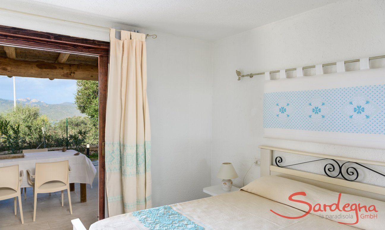 Villa Oleandro | Schlafzimmer mit Tür zum Garten mit sardischen Stoffen dekoriert Schlafzimmer mit sardischen Stoffen dekoriert