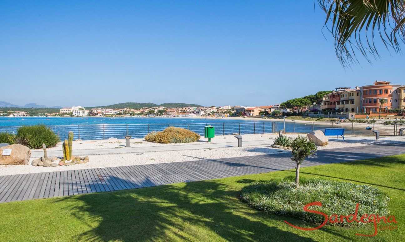 Stadtstrand mit Rasen und weißem Sand beim Hafen von Golfo Aranci