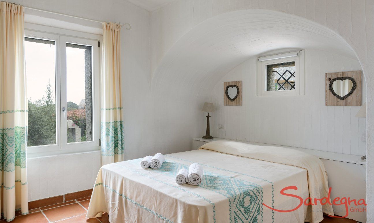 Li Conchi 30 | Schlafzimmer 1 mit Wandbogen und Fesnter zum Garten Hausdarstellung von Li Conchi 30