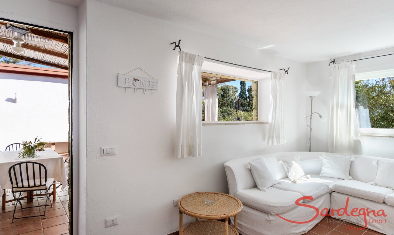 Casa Su Faru 3 | Sofaecke im Wohnzimmer mit Blick ins Grüne und auf die Terrasse Sofaecke im Wohnzimmer mit Blick in Grüne und auf die Terrasse von Su Faru 3 Pula