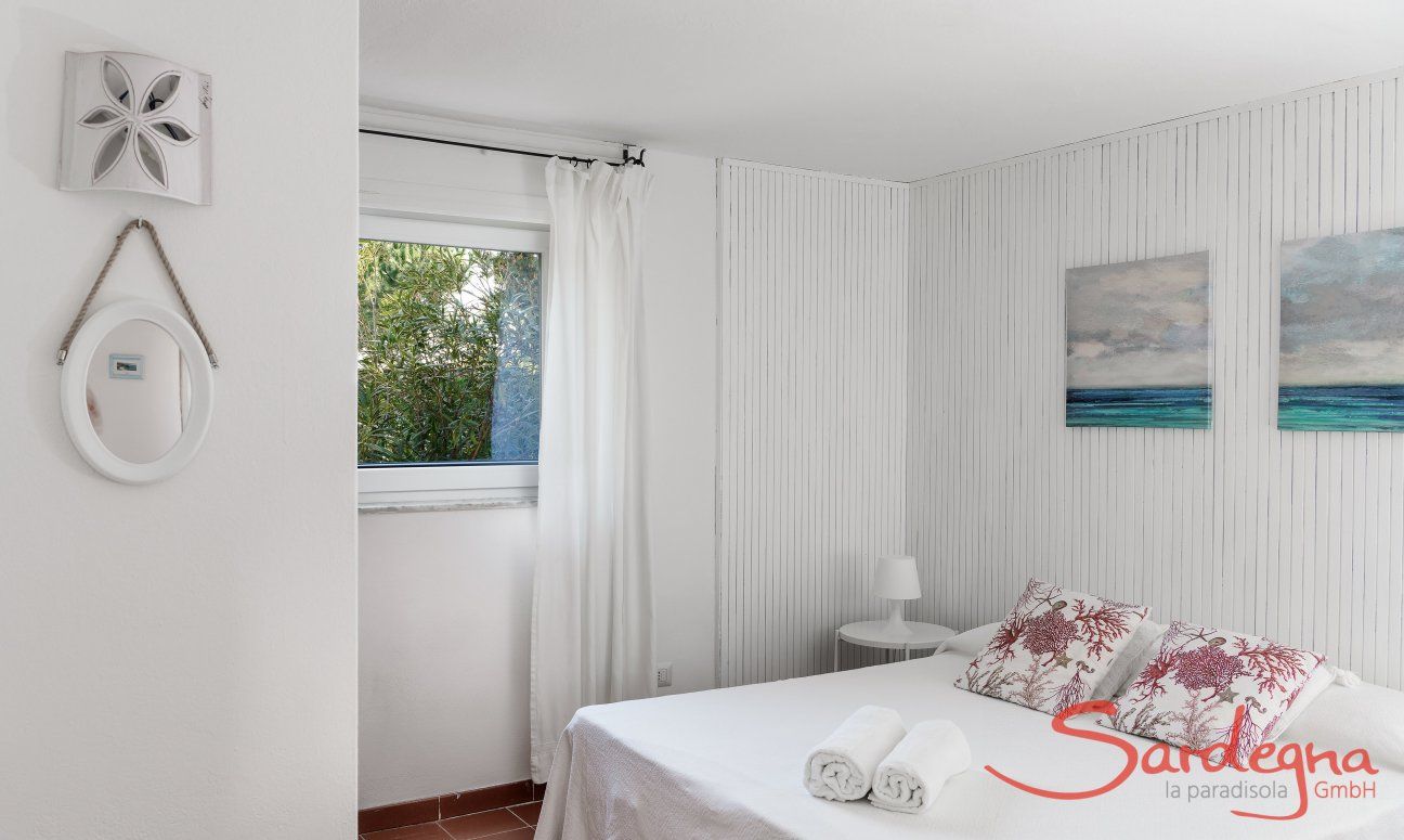 Casa Su Faru 3 | Schlafzimmer 1 mit Doppelbett und Fenster mit Blick in den Garten Schlafzimmer mit Doppelbett und Fenster ins Grüne Su Faru 3 Pula