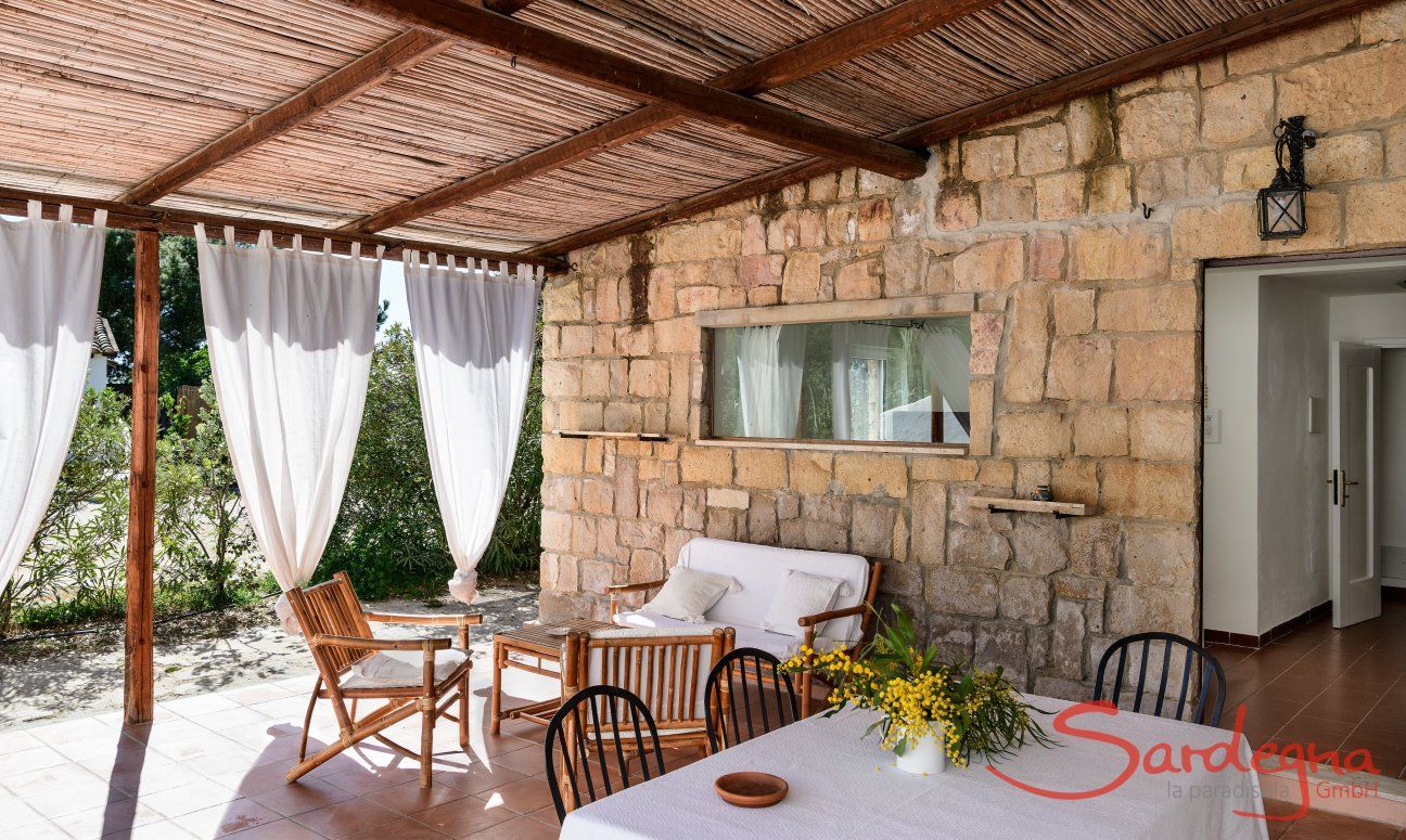 Casa Su Faru 3 | Überdachte Terrasse Su Faru 3 mit Esstisch und Sofamöbeln Überdachte Terrasse Su Faru 3 mit Esstisch und Sofamöbeln