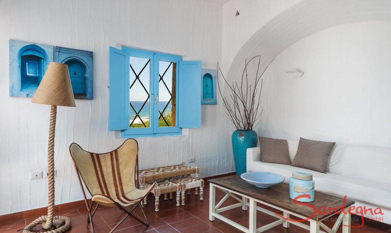Casa 17 | Wohnzimmer mit Sofaecke unter dem Fenster mit Meerblick Casa 17, Sant Elmo, Südsardinien