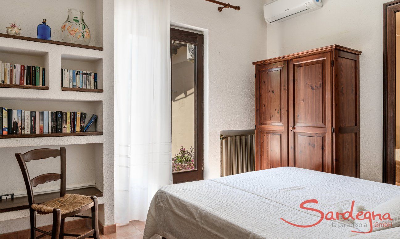 Villa Palme | Schlafzimmer 1 mit Doppelbett, Klimaanlage und Bücherregal Villa Palme, Costa Rei