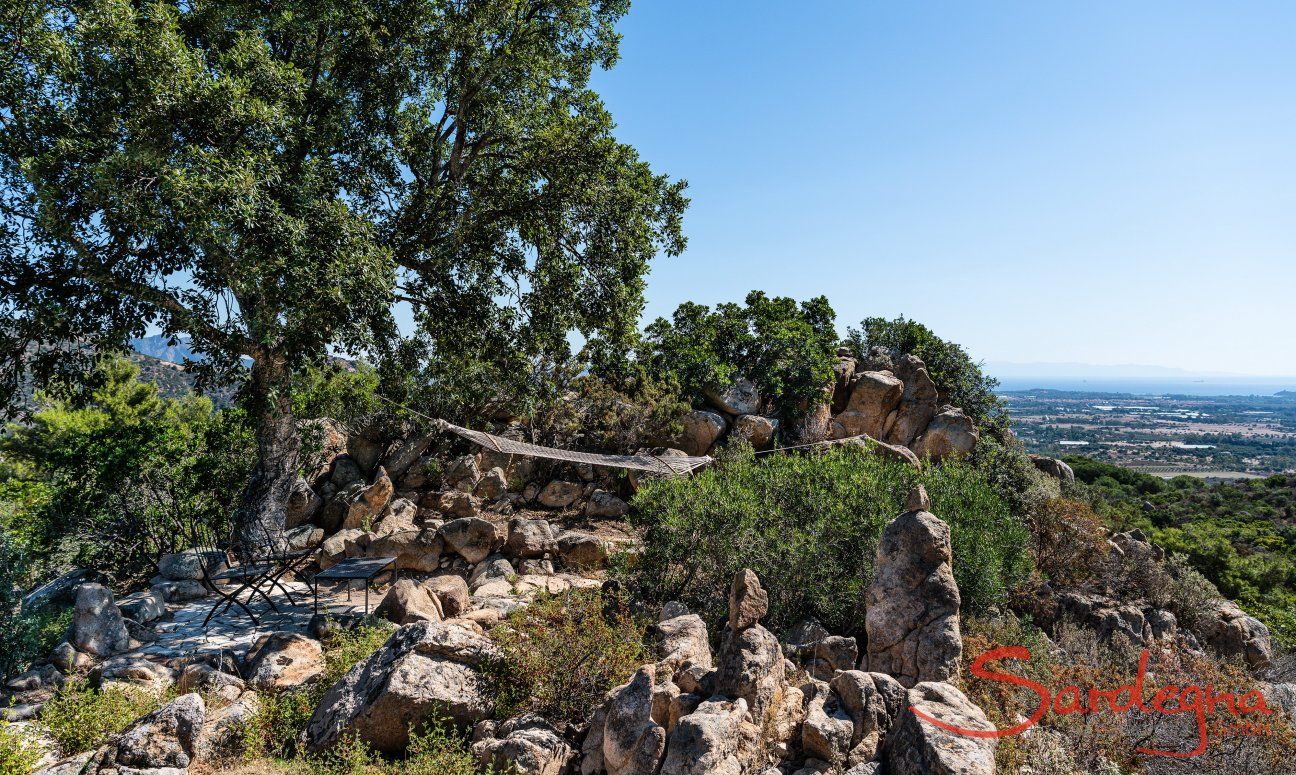 Villa Su Tauloni | Schattiger Platz unter einer alten Korkeiche mit Tisch und Stühlen und Hängematte zum Ausspannen Villa Su Tauloni, Is Molas, Südsardinien