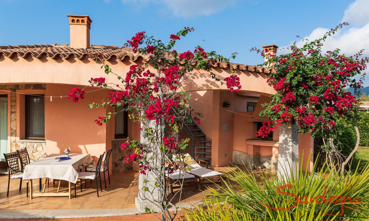 Villa Daniele | Aussenansicht vom Haus mit blühenden Bougainville vor der überdachten Terrasse Aussenansicht vom Haus