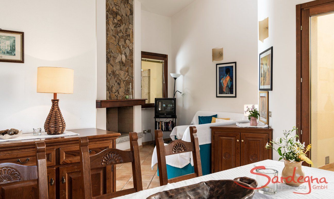 Villa Gioconda 21 | Rustikaler Esstisch und -möbel mit Blick in die Sofaecke im Wohnzimmer Hausdarstellung