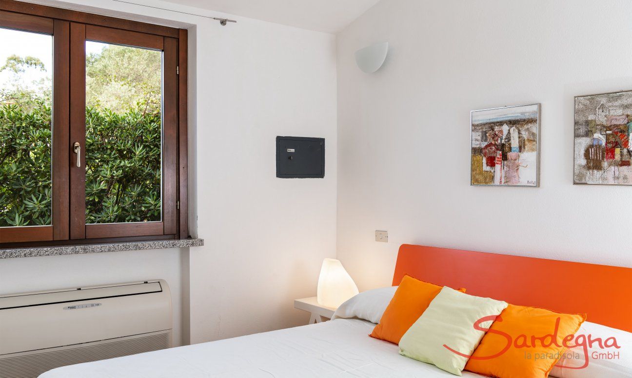 Villa Sandra 43 | Schlafzimmer 1 mit Doppelbett, Blick in den Garten und Klimaanlage Hausdarstellung