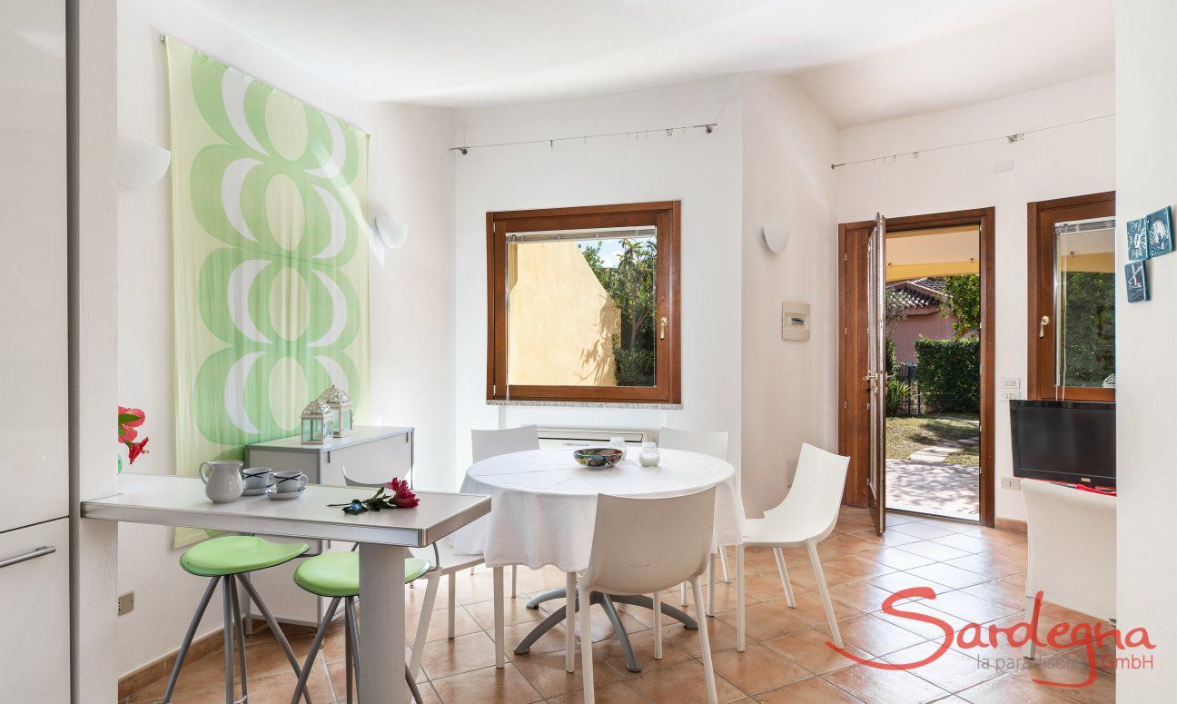 Villa Sandra 43 | Küchentheke und runder Esstisch, Tür zum Garten Hausdarstellung