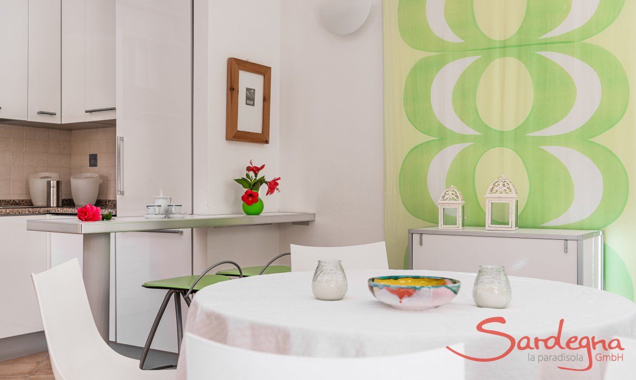 Villa Sandra 43 | Runder Esstisch und Blick in die Küche Hausdarstellung