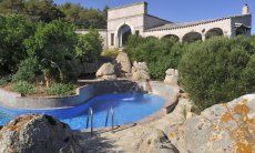 Villa Is Molas Monte | Der Pool ist bohnenförmig und inmitten von Granitfelsen und grüner, mediterraner Pflanzen neu