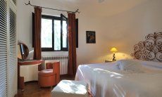 Villa Su Faru 1 | Schlafzimmer 1 mit elegantem schmiedeisernen Bett und Schminkkomode aus den sechziger Jahren Schlafzimmer 1 elegantem schmiedeisernen Bett und Schminkkomode aus den 60gern