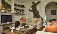 Villa Ulivi 12 | Wohnzimmer mit Stizgruppe um den Kamin und Blick in den Flur Wohnzimmer