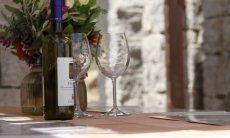 Li Conchi 29 | Sardischer Aperitif auf der Terrasse Weinflasche mit zwei Weingläsern