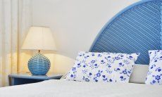Villa Bella | Doppelbett im Schlafzimmer 1 Doppelbett mit Kopfende, Nachtisch, und Lampe in hellblau