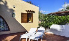 Villa Gaia | Terrasse mit Sonnenliegen und ein grosser Garten mit Tor zum Strand Terrasse mit Sonnenliegen