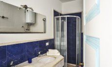Villa Torretta Chia | Badezimmer 4 mit Dusche und zwei Waschbecken und Waschmaschine Badezimmer 2 mit Dusche und zwei Waschbecken