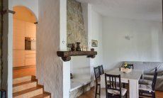 Villa Elisa | Wohnbereich mit Sofa, Esstisch und Kamin Wohnbereich mit Sofa, Esstisch und Kamin